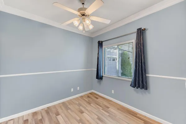 an empty room with windows and fan