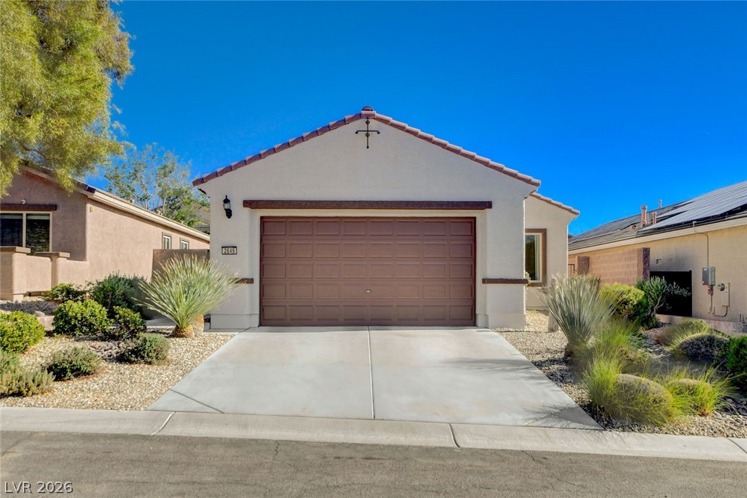 2649 Rue Marquette Avenue Henderson, NV 89044 - Photo 2 of 55 A well-maintained desert landscape frames this welcoming single-story home with an attached garage and concrete driveway.