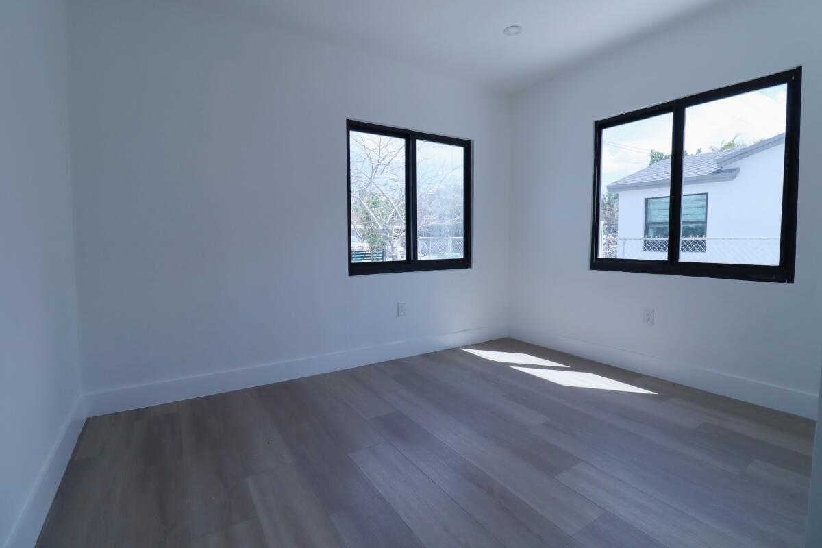 3040 Northwest 13th Avenue Miami, FL 33142 - Photo 11 of 16 an empty room with wooden floor and windows