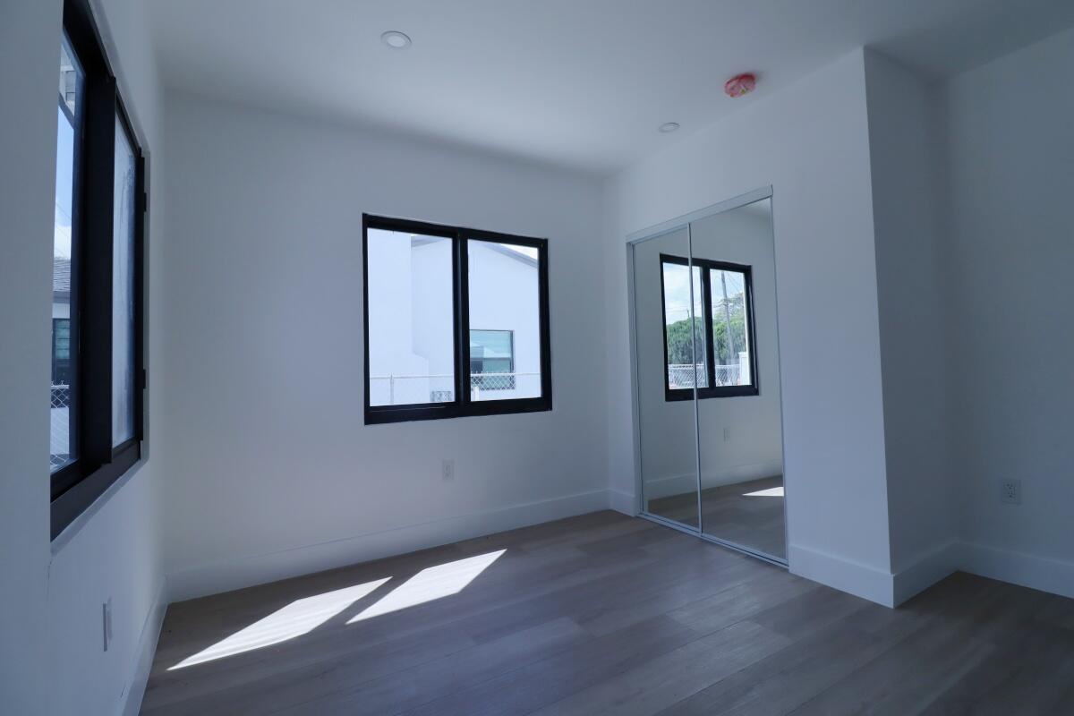3040 Northwest 13th Avenue Miami, FL 33142 - Photo 12 of 16 an empty room with wooden floor and windows