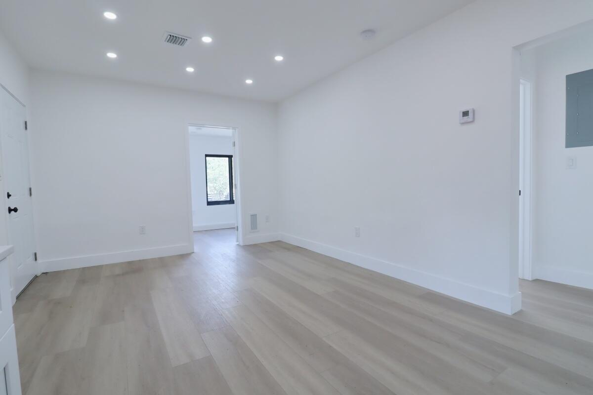 3040 Northwest 13th Avenue Miami, FL 33142 - Photo 6 of 16 an empty room with wooden floor and window