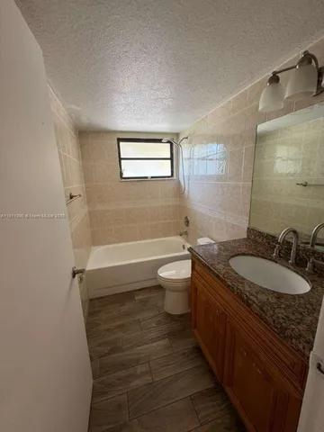 a bathroom with a granite countertop sink a toilet and a mirror