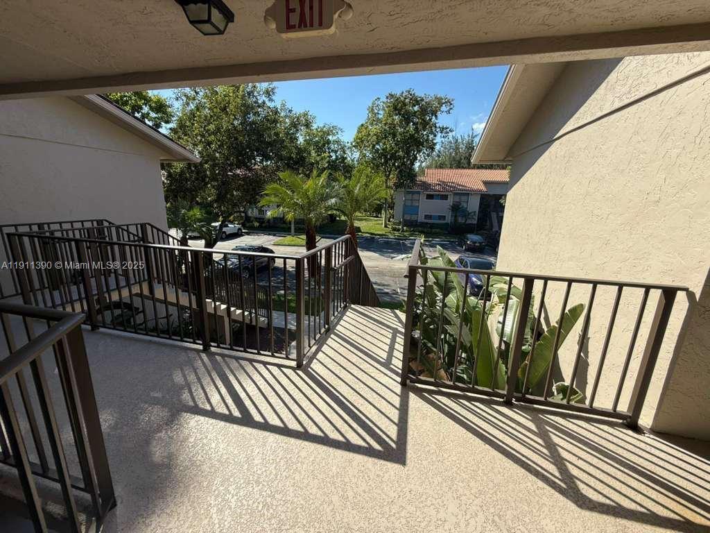 1580 Windorah Way, Unit E West Palm Beach, FL 33411 - Photo 3 of 20 a balcony with wooden floor and outdoor seating