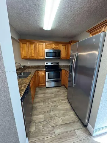 a kitchen with granite countertop a stove and a refrigerator