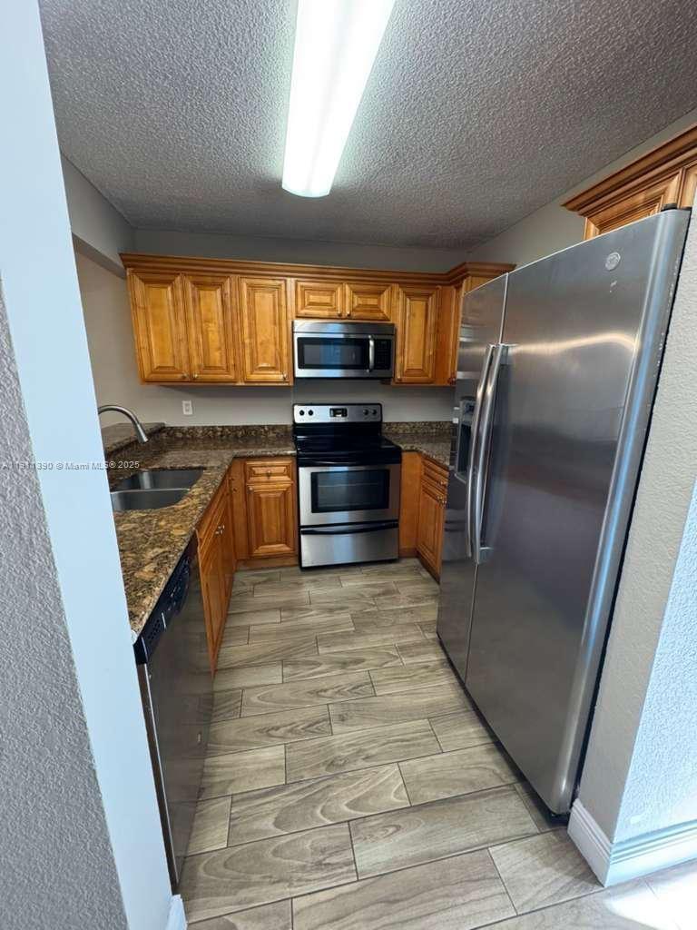 1580 Windorah Way, Unit E West Palm Beach, FL 33411 - Photo 6 of 20 a kitchen with granite countertop a stove and a refrigerator