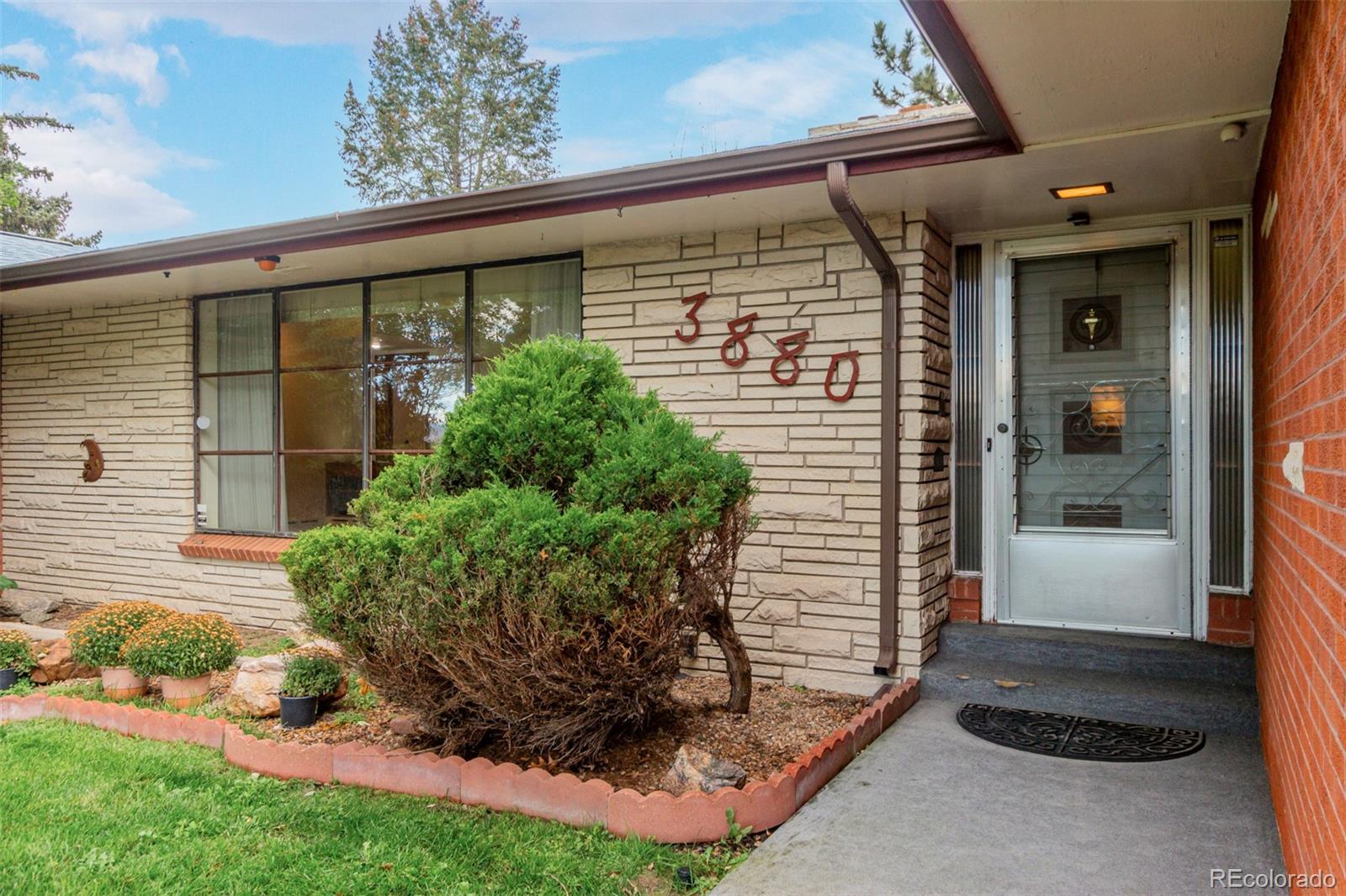 3880 Independence Court Wheat Ridge, CO 80033 - Photo 13 of 47 a front view of a house with garden