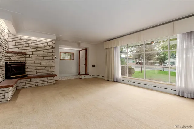 a view of an empty room with a fireplace and a window