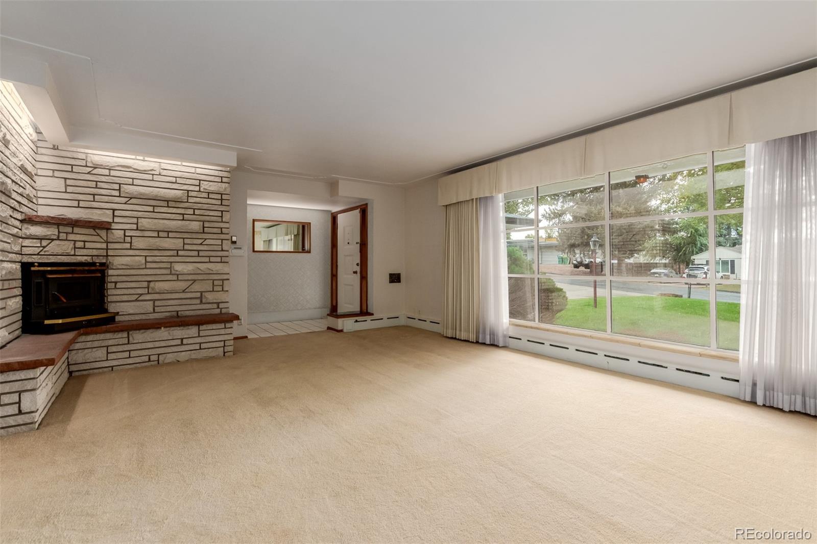 3880 Independence Court Wheat Ridge, CO 80033 - Photo 16 of 47 a view of an empty room with a fireplace and a window