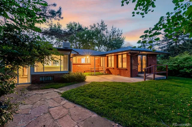 a view of a house with backyard and sitting area