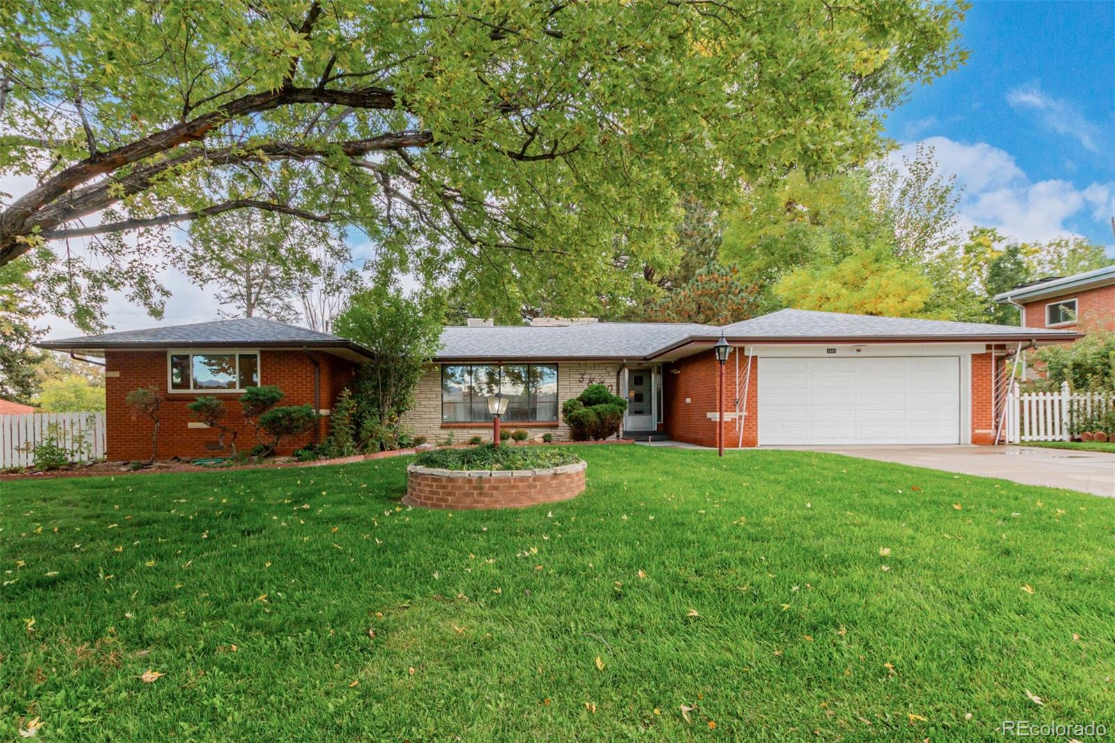 3880 Independence Court Wheat Ridge, CO 80033 - Photo 9 of 47 a front view of a house with a garden and trees