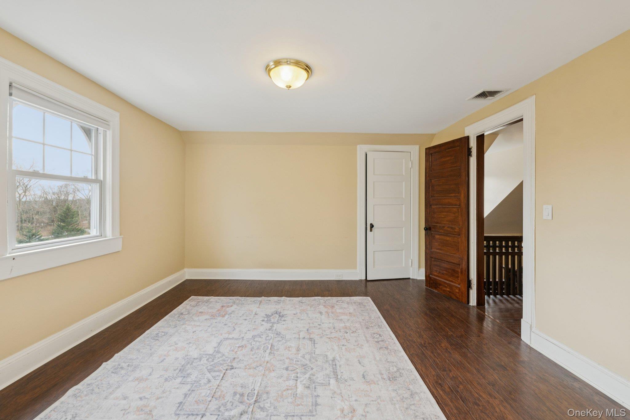 397 Split Rock Road Syosset, NY 11791 - Photo 25 of 29 an empty room with wooden floor and windows