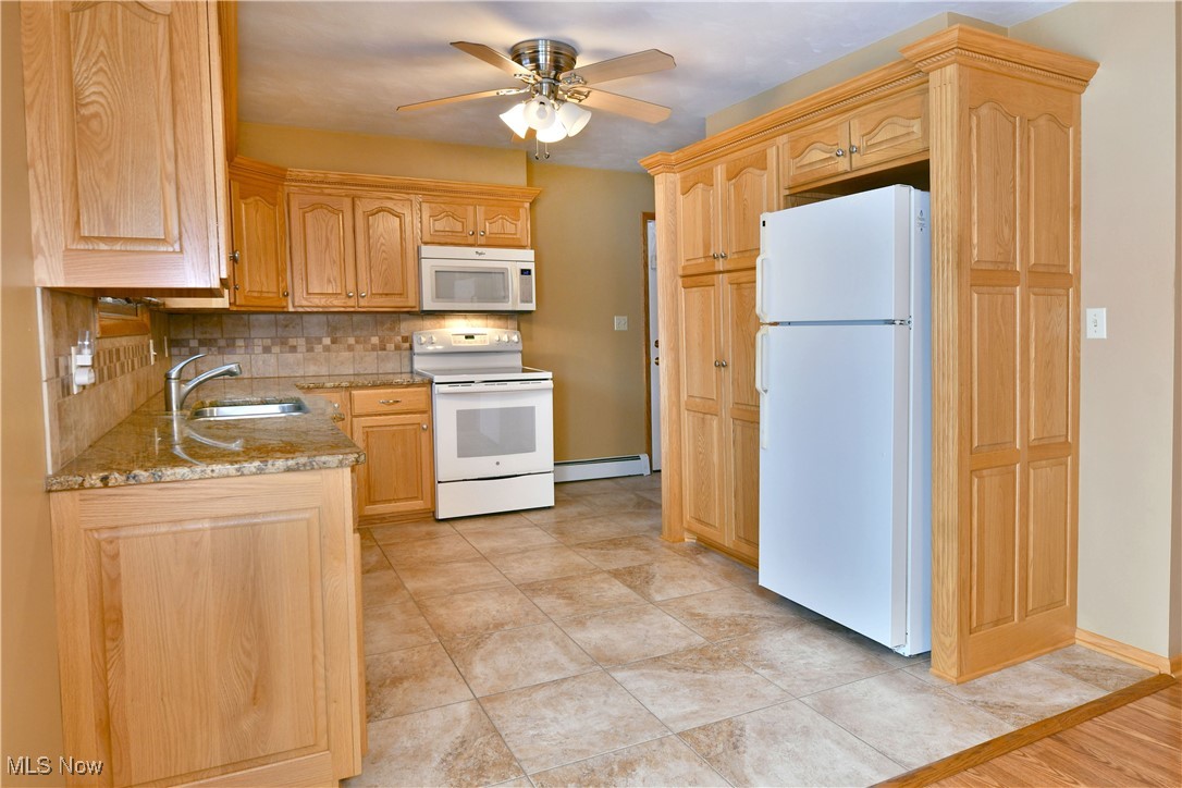 7155 Drake State Line Road Burghill, OH 44404 - Photo 14 of 50 Kitchen with white appliances, light brown cabinets, light stone counters, and decorative backsplash