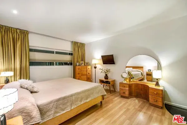 a bedroom with a bed and wooden floor