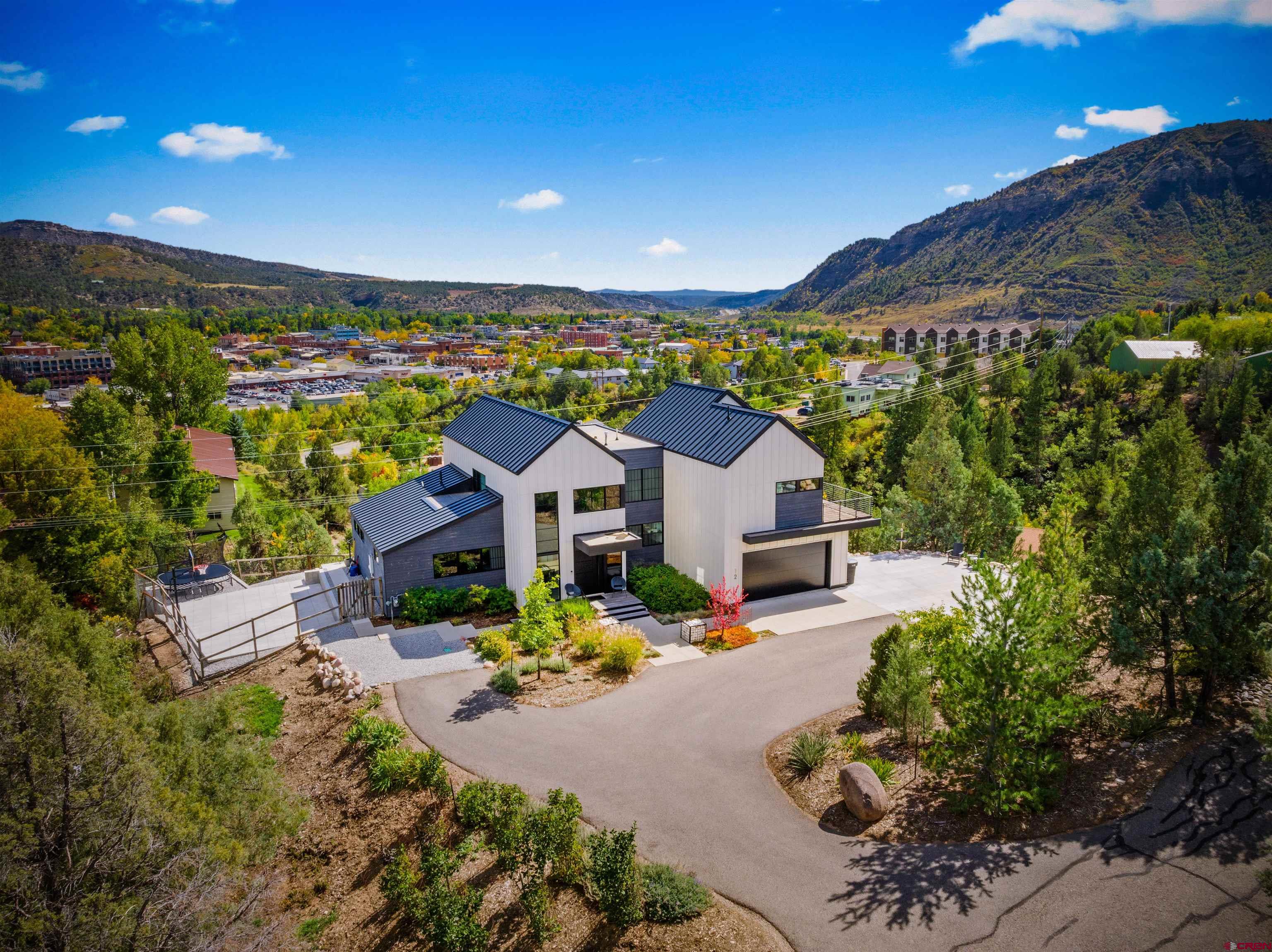 a view of a house with a big yard and potted plants