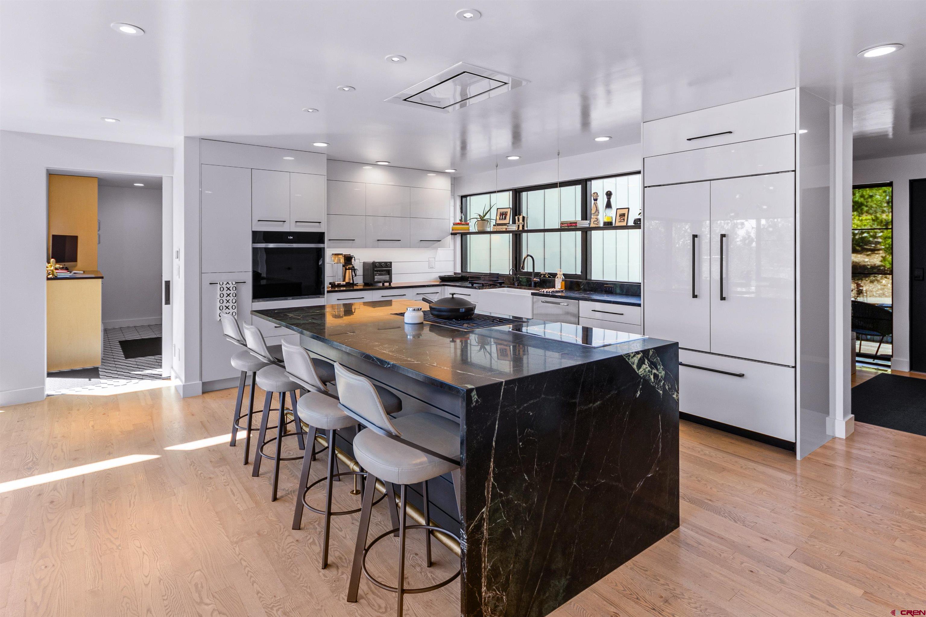 12 Falcon Way Durango, CO 81301 - Photo 12 of 38 a kitchen with granite countertop a table chairs microwave and refrigerator