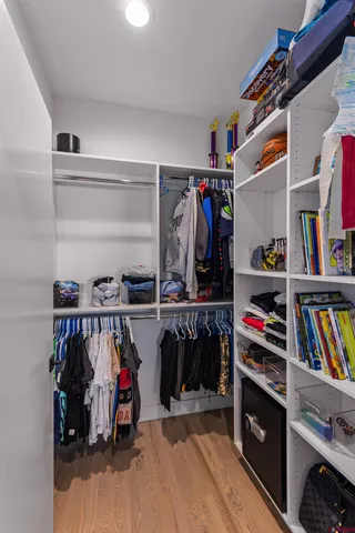 a view of walk in closet with clothes and shoes