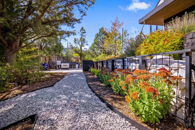 a view of a pathway with a flower garden