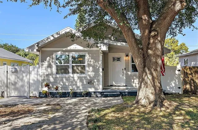 a front view of a house with a tree