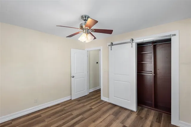 a view of an empty room with closet and a window