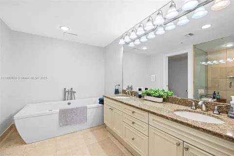 a spacious bathroom with a double vanity sink mirror and bathtub