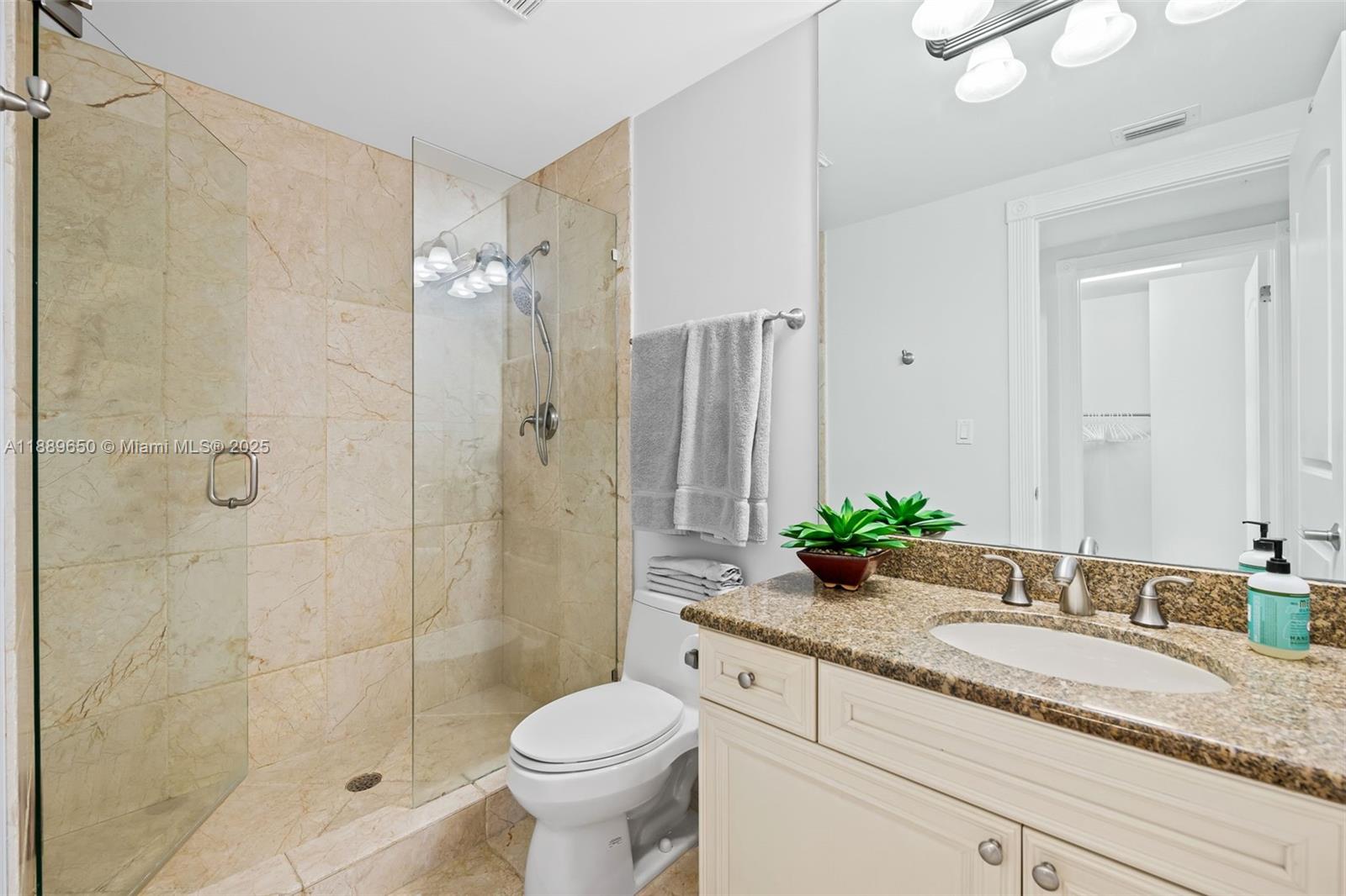 1414 Southeast 12th Street, Unit 1B Fort Lauderdale, FL 33316 - Photo 22 of 34 a bathroom with a granite countertop sink toilet mirror and shower