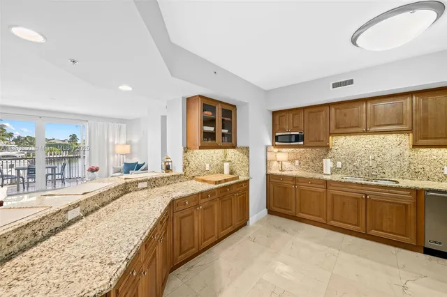 a large kitchen with granite countertop a sink and cabinets