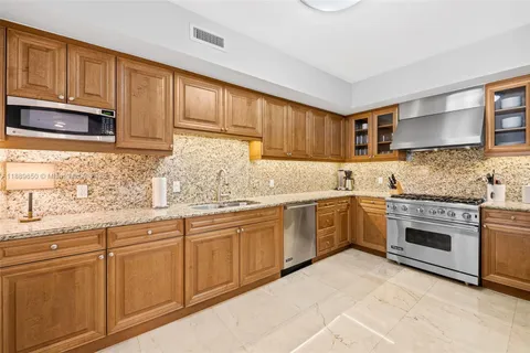 a kitchen with granite countertop cabinets stainless steel appliances and sink