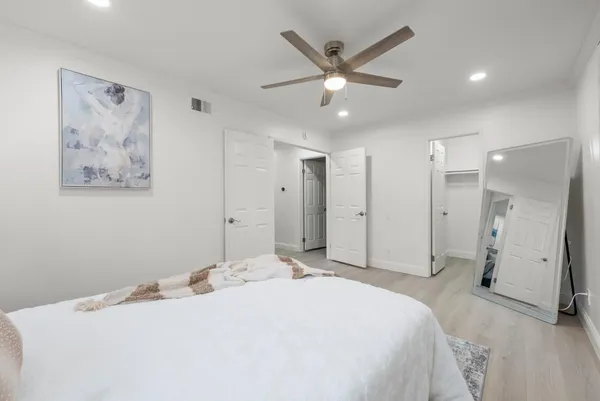a spacious bedroom with a bed and a chandelier