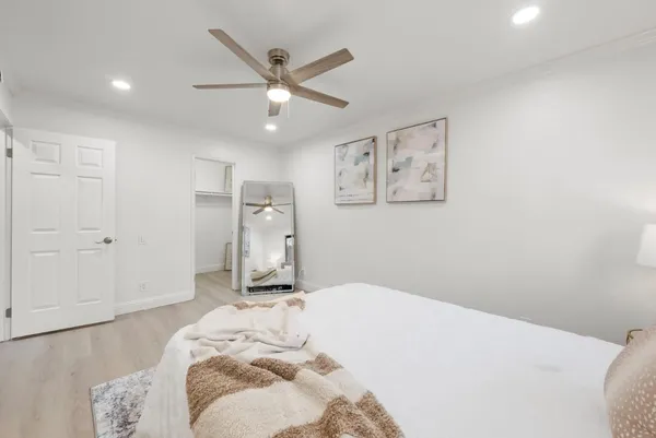 a bedroom with a large bed and a chandelier