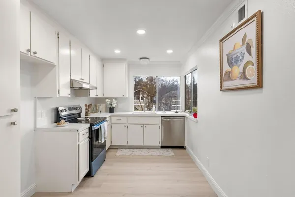 a kitchen with stainless steel appliances granite countertop a stove a sink and a refrigerator
