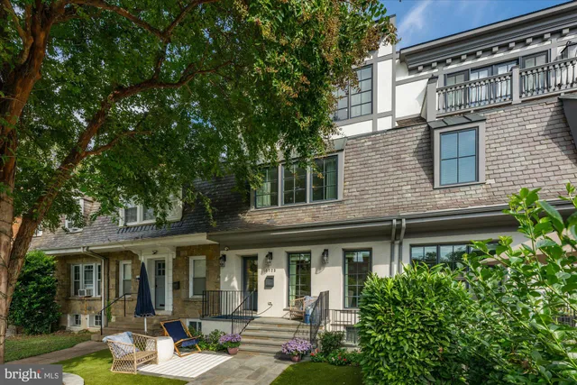 a view of a brick house with a large windows and a table and chair