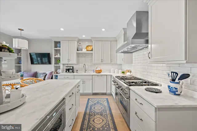 a kitchen with stainless steel appliances a sink dishwasher stove refrigerator and cabinets with wooden floor