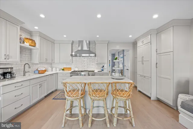 a large kitchen with kitchen island a island a stove a cabinets and a refrigerator