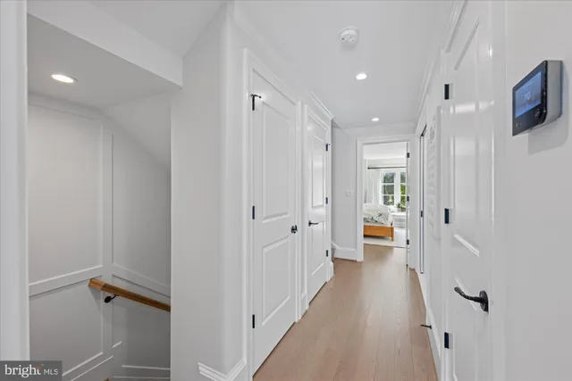 a view of a hallway with a chair and a refrigerator