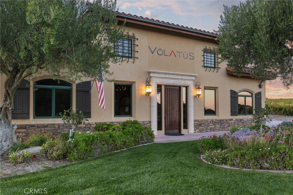 a view of a house with brick walls and a yard with plants