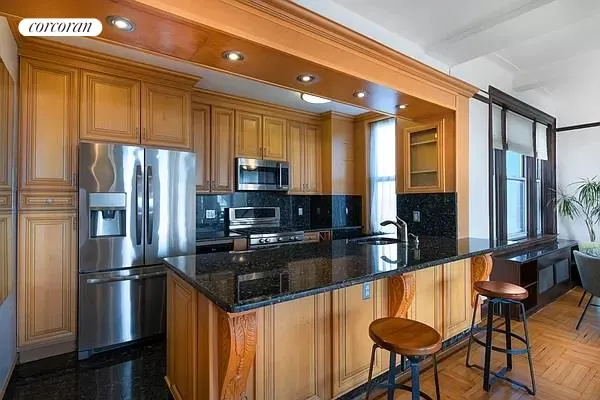 a kitchen with stainless steel appliances granite countertop a refrigerator a stove and a sink with granite countertops