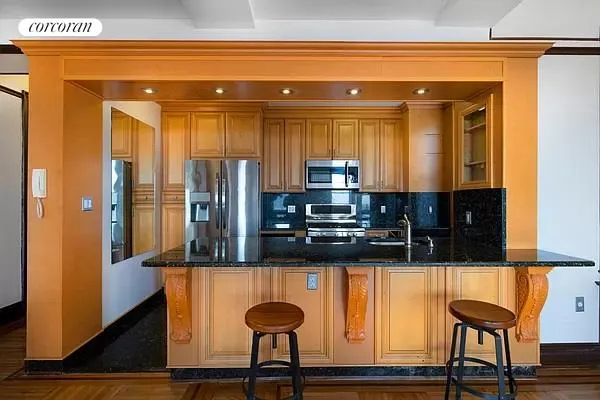 a kitchen with stainless steel appliances kitchen island granite countertop a refrigerator and a stove top oven