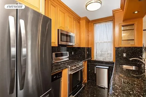 a kitchen with stainless steel appliances granite countertop a refrigerator stove and sink