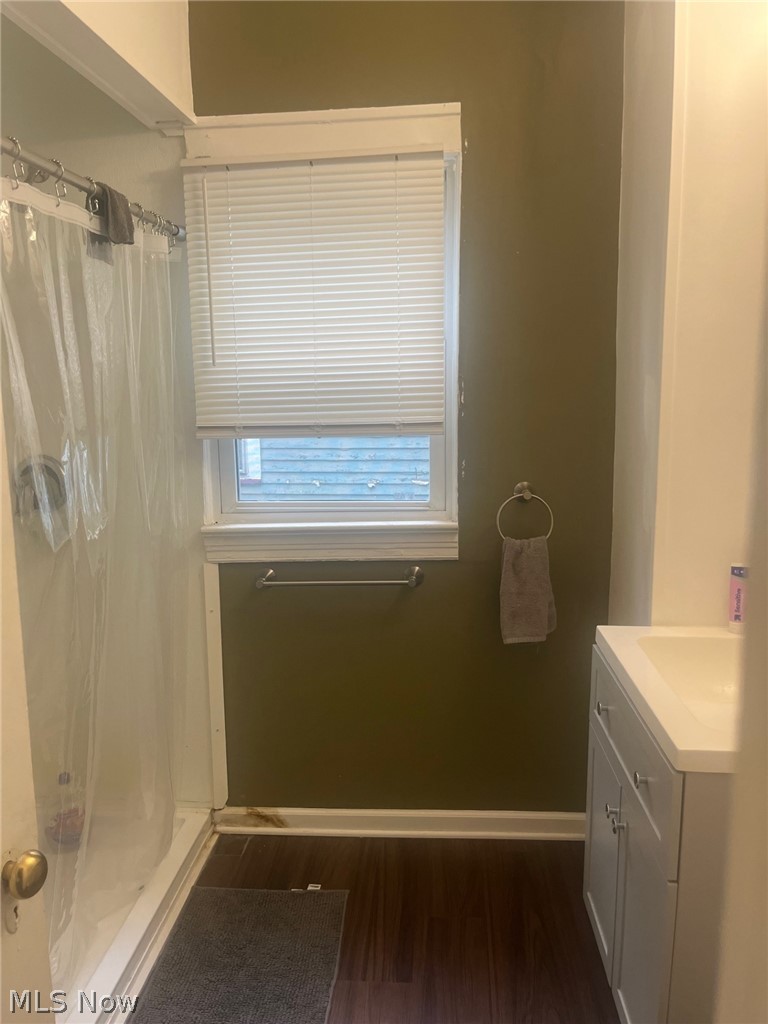 1101 Carlyon Road East Cleveland, OH 44112 - Photo 17 of 23 Bathroom featuring a white shower with a clear shower curtain, a window with horizontal blinds, and a white vanity with an integrated sink