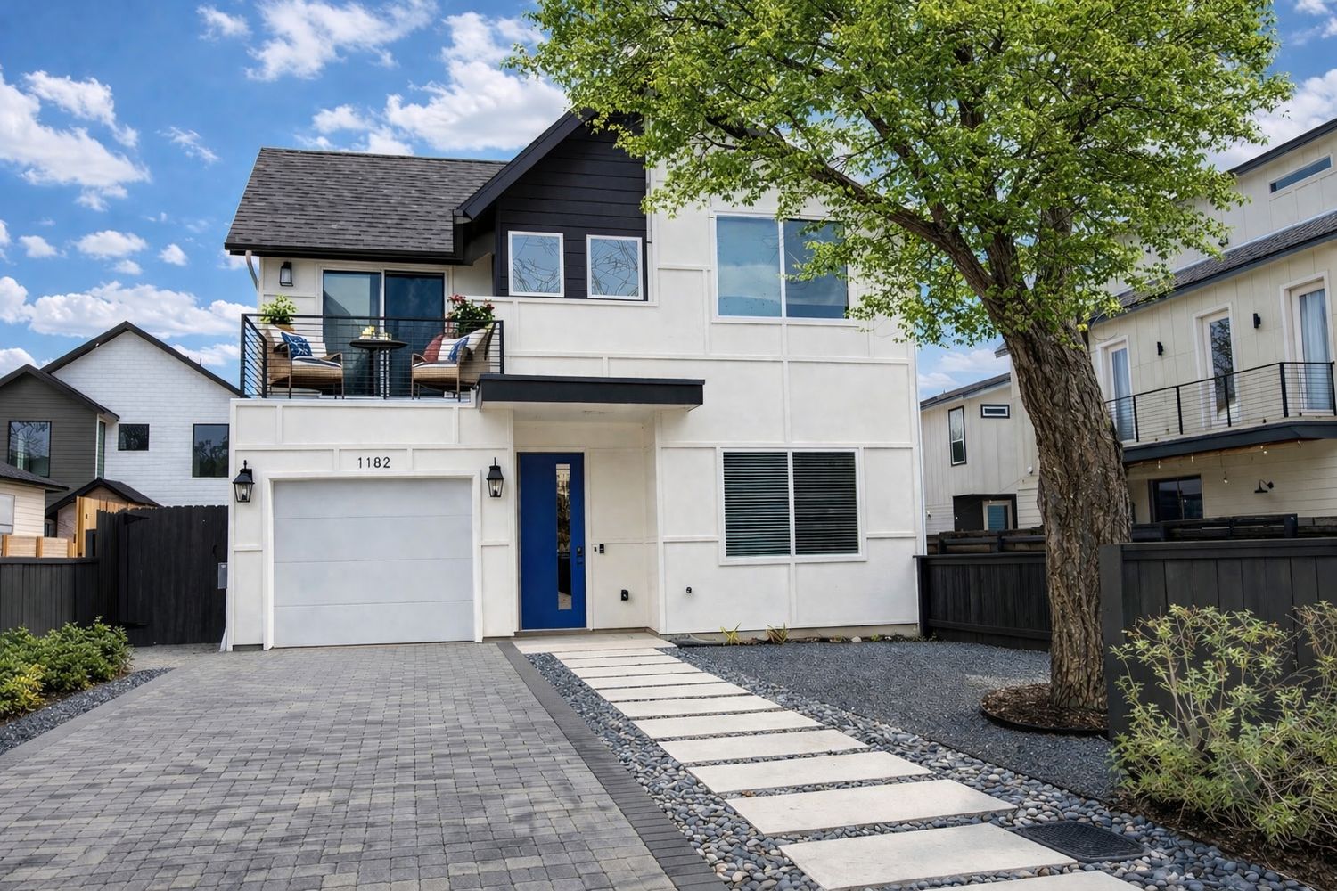 View of front of house featuring a balcony, stucco siding, decorative driveway, an attached garage, and a shingled roof