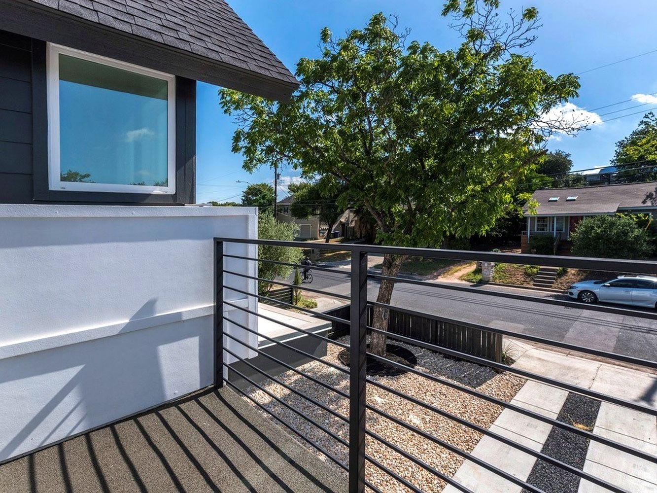 1182 Ridgeway Drive, Unit A Austin, TX 78702 - Photo 24 of 27 a view of a balcony with two chairs and a potted plant on a wooden floor