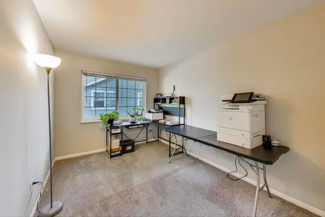 a view of a workspace with furniture and a window