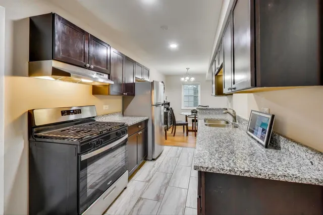 a kitchen with granite countertop stainless steel appliances and wooden cabinets