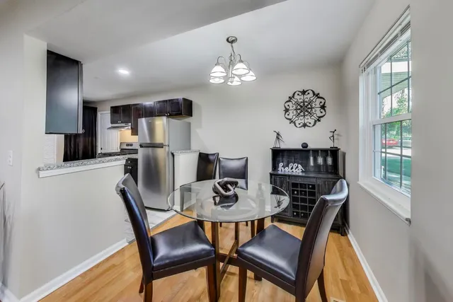 a view of a dining room with furniture a chandelier and wooden floor