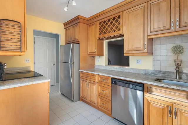 a kitchen with stainless steel appliances granite countertop a refrigerator and a sink