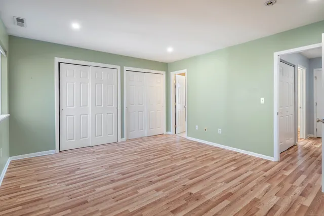 a view of empty room with wooden floor