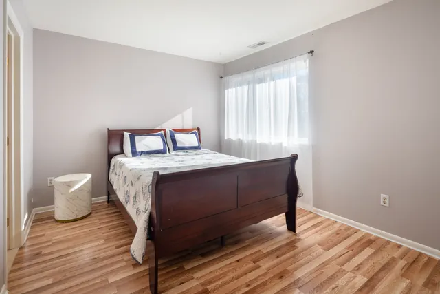 a bedroom with a bed and wooden floor