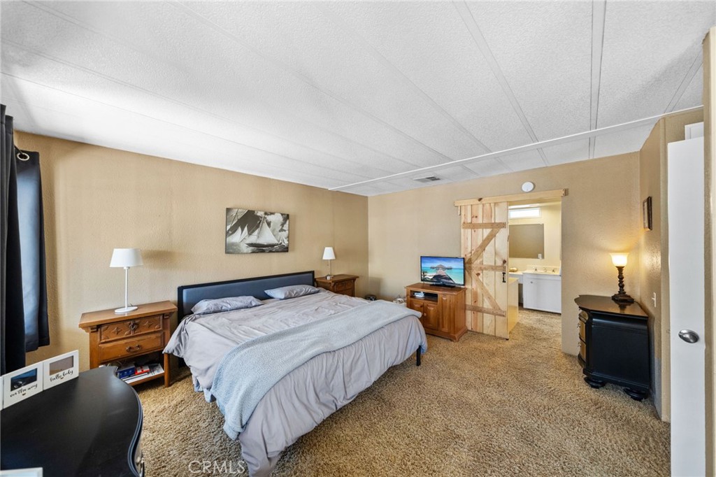 26311 Jackson Avenue, Unit 35 Murrieta, CA 92563 - Photo 13 of 41 a bedroom with a bed and wooden floor