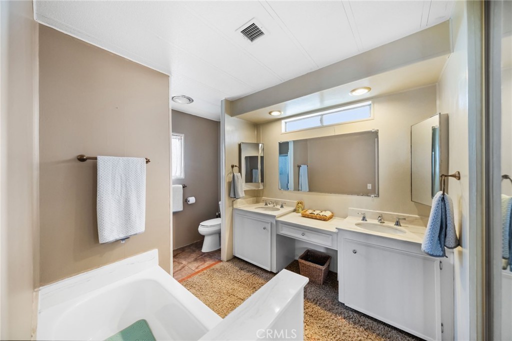 26311 Jackson Avenue, Unit 35 Murrieta, CA 92563 - Photo 15 of 41 a bathroom with a sink a toilet and a mirror