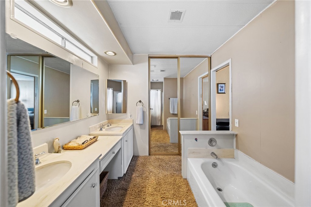 26311 Jackson Avenue, Unit 35 Murrieta, CA 92563 - Photo 17 of 41 a spacious bathroom with a granite countertop tub sink and mirror